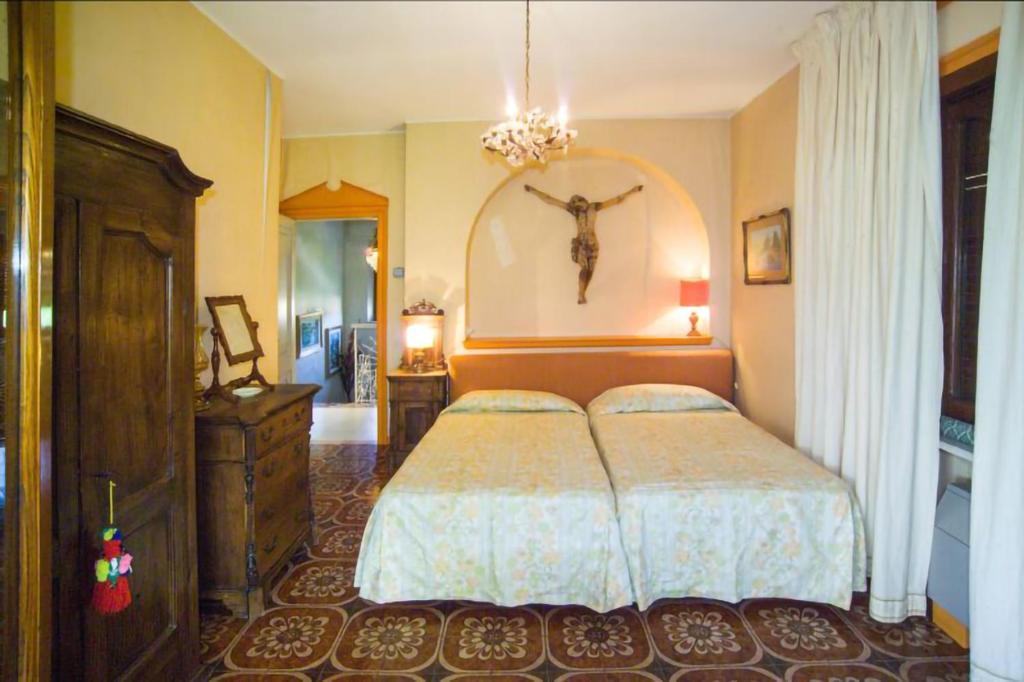 - une chambre avec un lit et une croix sur le mur dans l'établissement Villa alkantara, à Taormine 15 autres photos