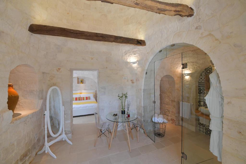 La salle de bains est pourvue d'une douche en verre et d'une table. dans l'établissement Trulli Santa Croce - Luxury Holiday -, à Locorotondo
