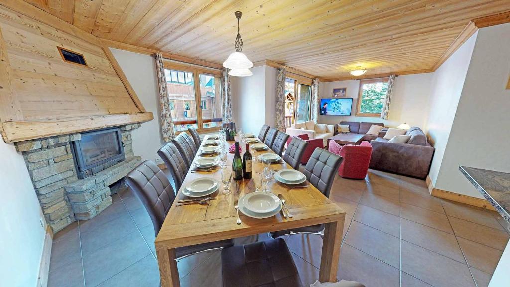 une salle à manger avec une grande table et une cheminée dans l'établissement Le Sabot de Vénus, à Val Thorens