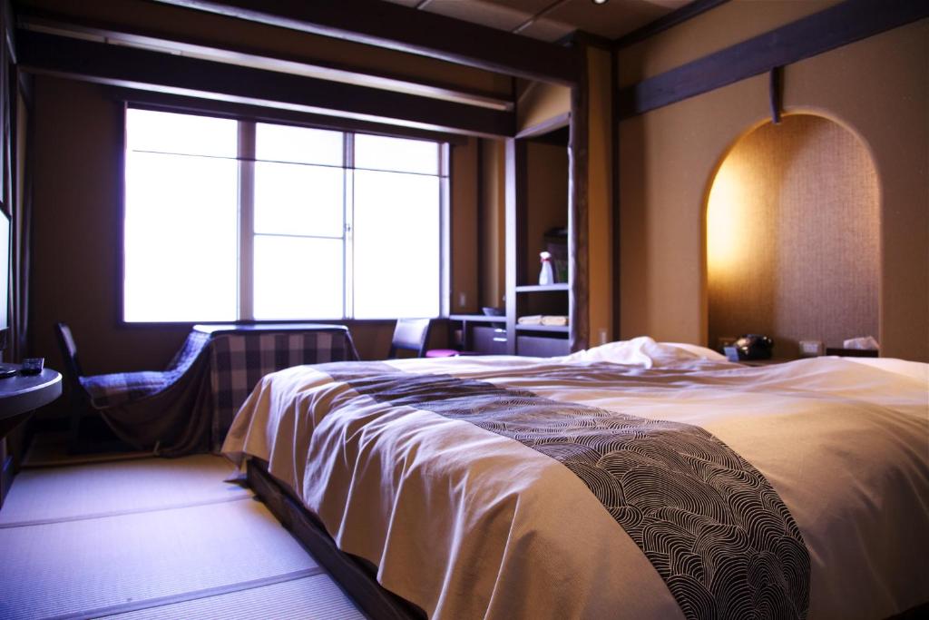 une chambre avec un grand lit et une fenêtre dans l'établissement Nakaya Ryokan, à Minakami