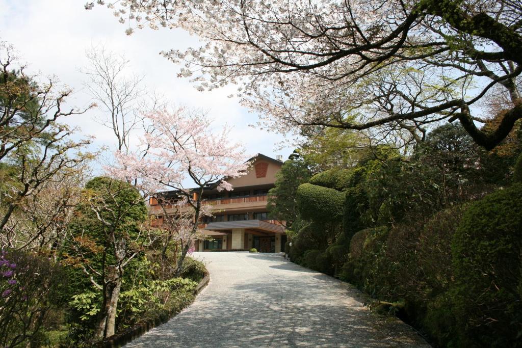 une route menant à un bâtiment planté d'arbres à fleurs dans l'établissement Senkyoro, à Hakone