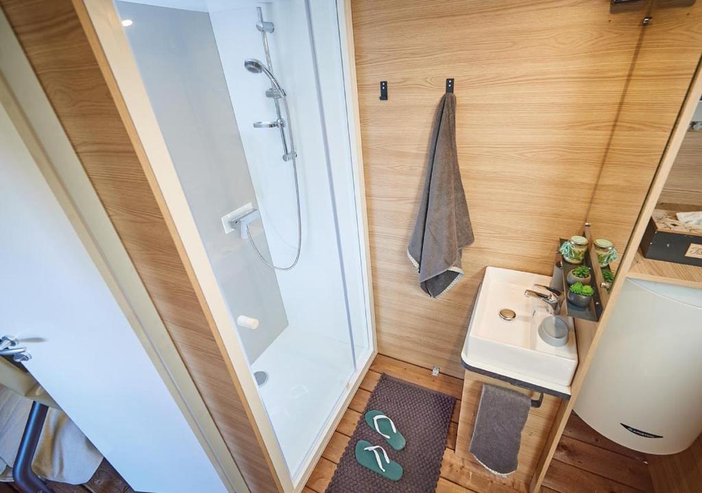 La petite salle de bains est pourvue d'une douche et d'un lavabo. dans l'établissement Camping Europ'Camping - Maeva, à Ascarat
