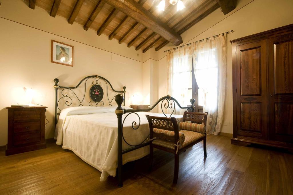 une chambre avec un lit et deux chaises et une fenêtre dans l'établissement Villa Rondinocco, à Civitella in Val di Chiana