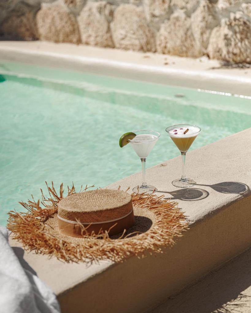- un gâteau et deux verres sur une table à côté de la piscine dans l'établissement Pure House Marrakech, à Marrakech