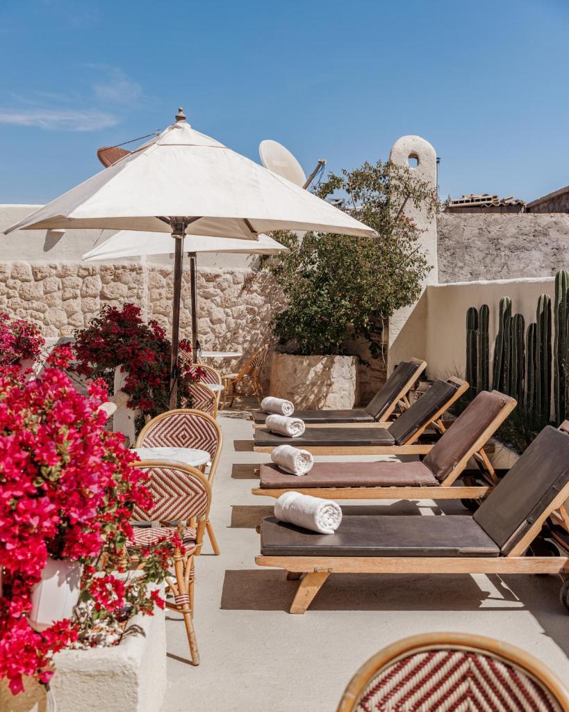 - une rangée de chaises longues, un parasol et des fleurs dans l'établissement Pure House Marrakech, à Marrakech 37 autres photos