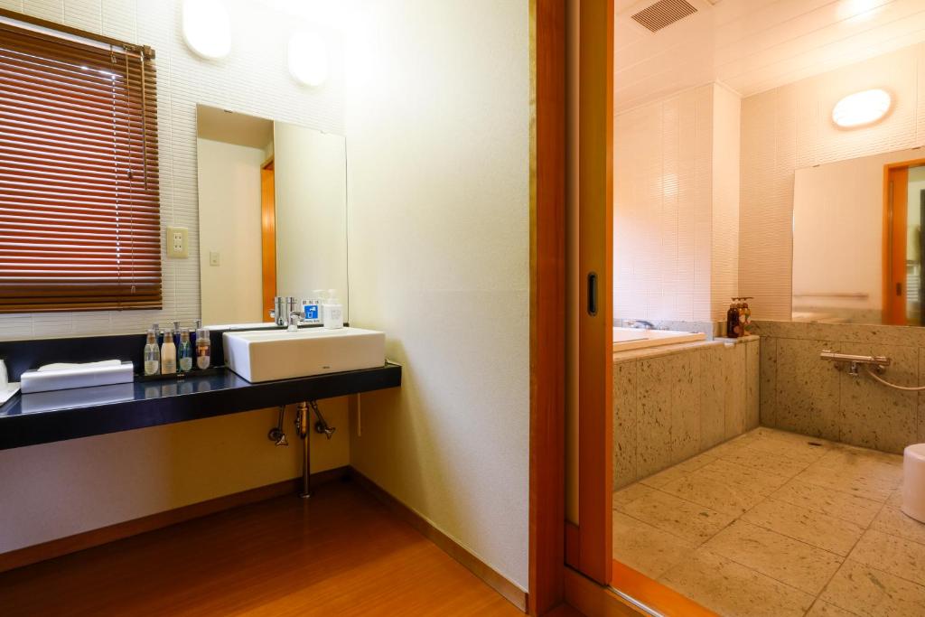 une salle de bain avec un lavabo et un miroir dans l'établissement Nikko Hoshino Yado, à Nikkō