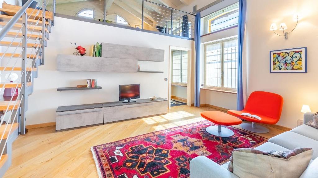 - un salon avec un escalier et une chaise rouge dans l'établissement Uvaspina 8, Emma Villas, à Antignano