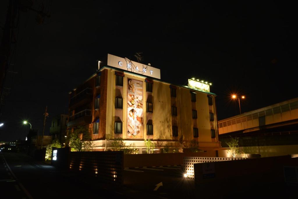 un bâtiment avec un panneau dessus la nuit dans l'établissement HOTEL CHANT - Adult Only 大人専用, à Sakai