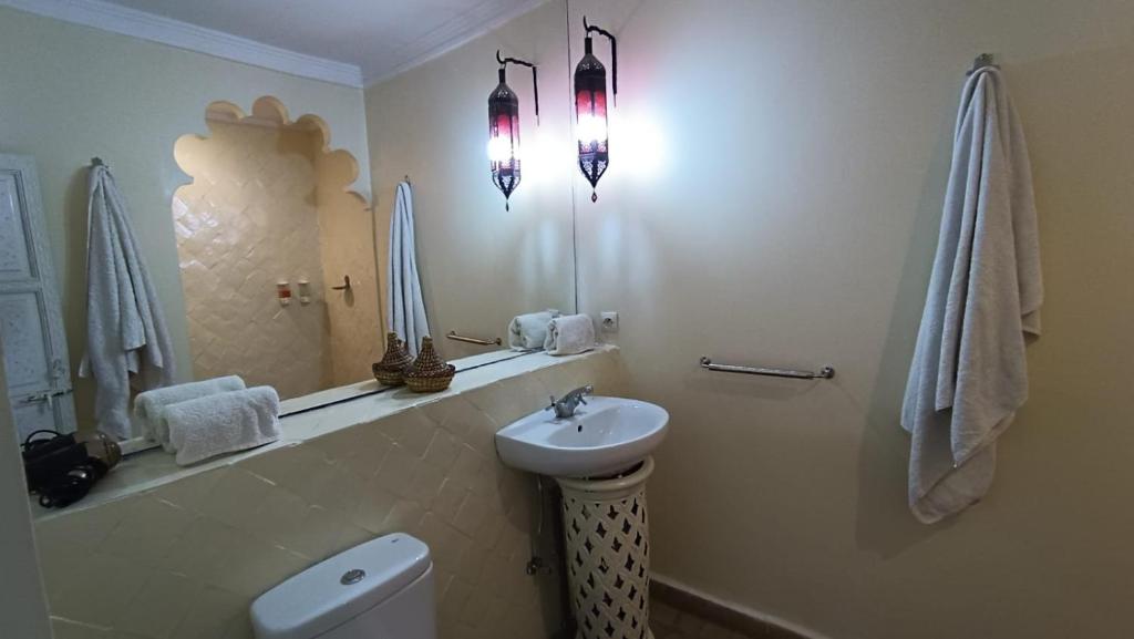 une salle de bain avec un lavabo, des toilettes et un miroir dans l'établissement Riad Hugo, à Marrakech 37 autres photos