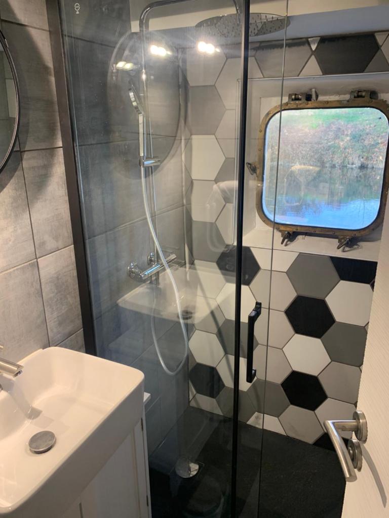 une salle de bain avec douche et lavabo dans l'établissement chambres dans peniche un air de vacances, à Toulouse