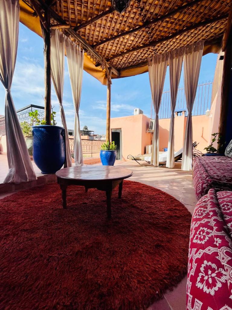 - un salon avec une table sur un tapis rouge dans l'établissement Riad Dar Lilas, à Marrakech