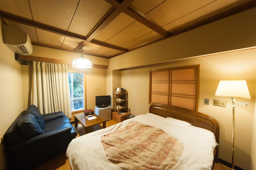 une chambre avec un lit, une chaise et une lampe dans l'établissement Hotel Edoya, à Tokyo