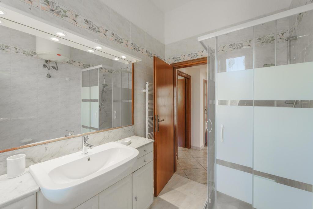 une salle de bain blanche avec un lavabo et une douche dans l'établissement Villa Mimosa con Piscina - Goelba, à Marmi