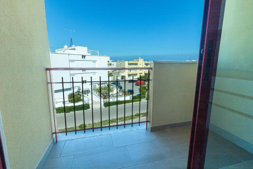 un balcon avec vue sur un immeuble dans l'établissement Appartamenti Craulo, à Otrante