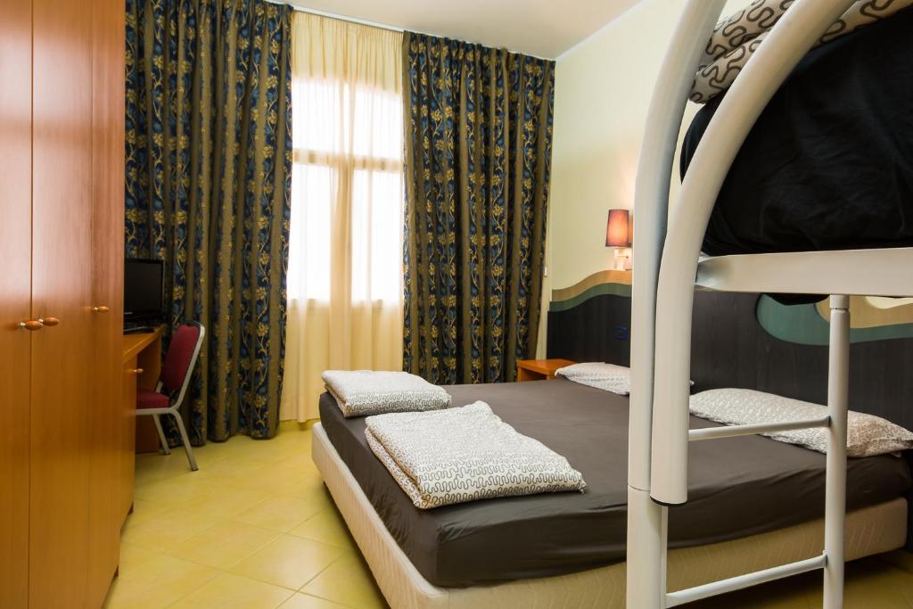 une chambre avec un lit superposé et un bureau dans l'établissement HOTEL SOLE, à San Menaio