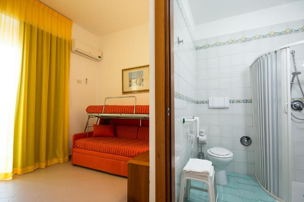 La salle de bains est pourvue d'un lit superposé rouge et de toilettes. dans l'établissement HOTEL SOLE, à San Menaio