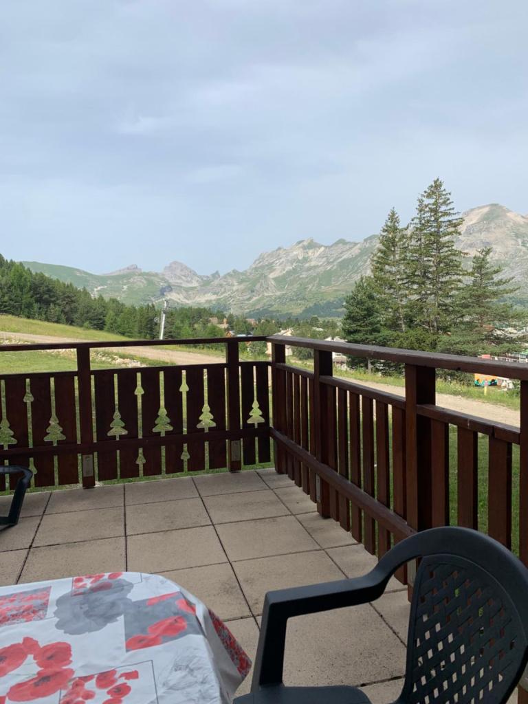 un balcon avec une table et une vue sur les montagnes dans l'établissement l'appart sur les pistes, à Saint-Étienne-en-Dévoluy