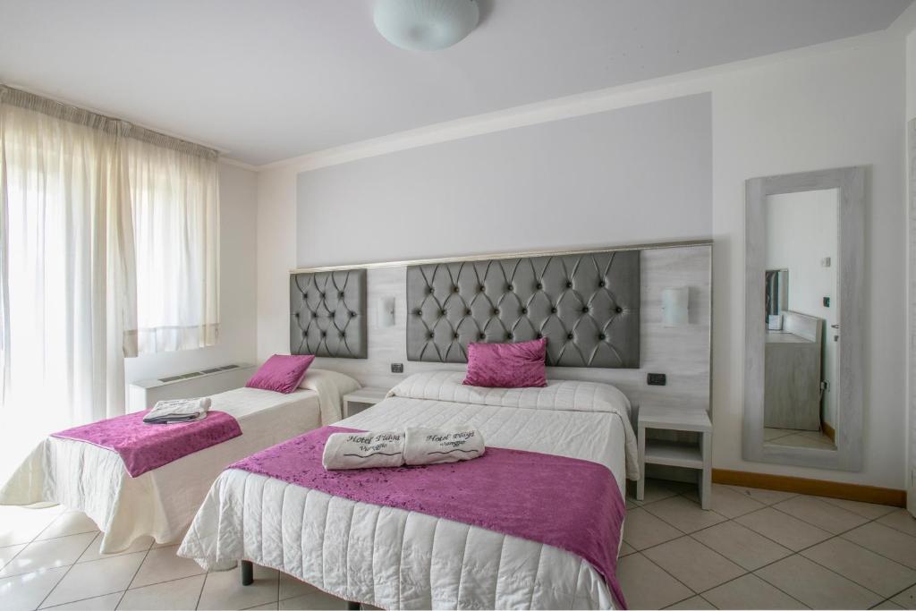 une chambre d'hôtel avec deux lits avec des draps violets dans l'établissement Hotel Playa, à Viareggio 105 autres photos