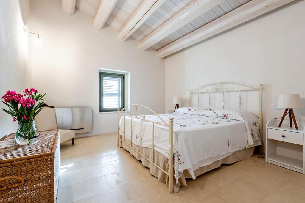 - une chambre blanche avec un lit et une table fleurie dans l'établissement Casale Donna Costanza, à Scicli 36 autres photos