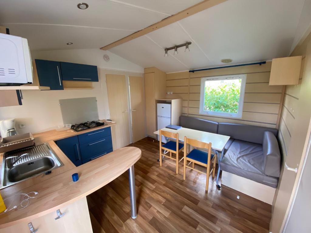 une petite cuisine avec une table et des chaises dans une pièce dans l'établissement mobil-home au Parc des roches, à Saint-Chéron