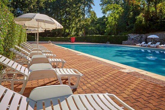 - une rangée de chaises longues blanches et une piscine dans l'établissement mobil-home au Parc des roches, à Saint-Chéron