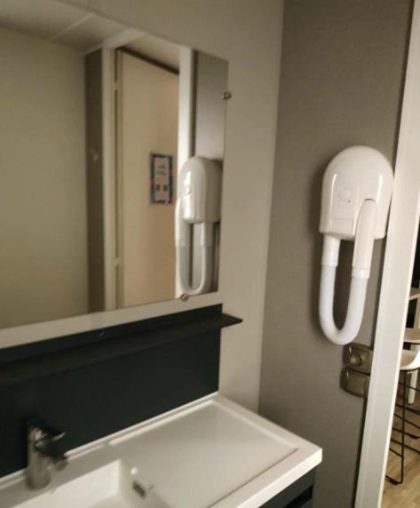 La salle de bains est pourvue d'un miroir et d'un lavabo blanc. dans l'établissement Charmant mobilhome camping Les Sables d'Or 4 étoiles, au Grau-dʼAgde