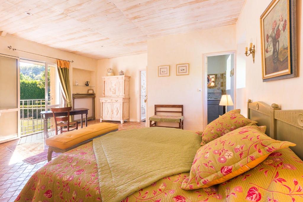 une chambre avec un grand lit et une table dans l'établissement Le Moulin de la Maison des Templiers, à Saint-Cernin-de-Larche 37 autres photos