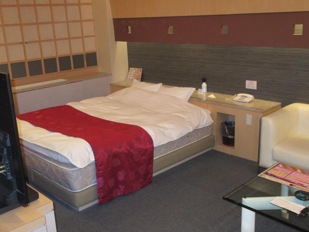 une chambre d'hôtel avec un lit avec une couverture rouge dans l'établissement Hotel Shuyukan (Adult Only), à Izumi-Sano 26 autres photos