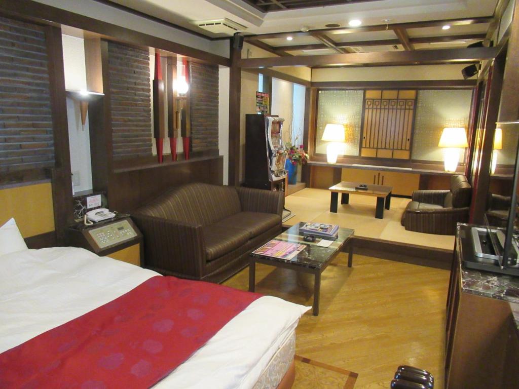 une chambre d'hôtel avec un lit et un salon dans l'établissement Hotel Shuyukan (Adult Only), à Izumi-Sano