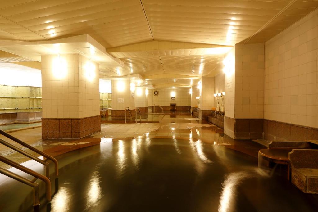 - un couloir avec piscine d'eau dans un bâtiment dans l'établissement Sounkyo Kankou Hotel, à Kamikawa