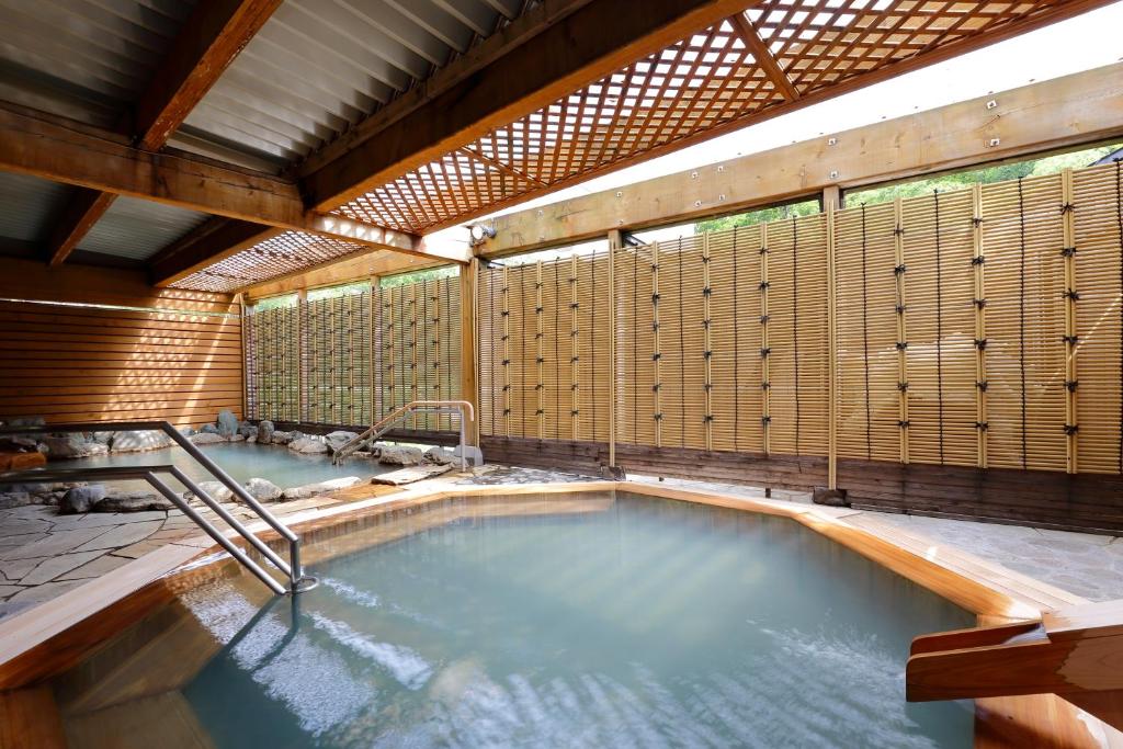 - une grande piscine dans un bâtiment aux murs en bois dans l'établissement Sounkyo Kankou Hotel, à Kamikawa