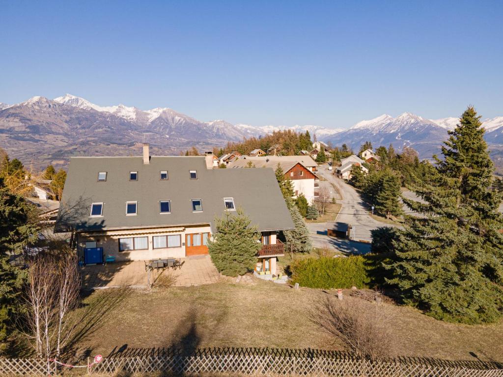 une vue aérienne d'une maison avec des montagnes en arrière-plan dans l'établissement Maison L'Aiguille - 2 appartements, 5 chambres et table d'hôtes au pied de la montagne à la station de Laye, à Laye