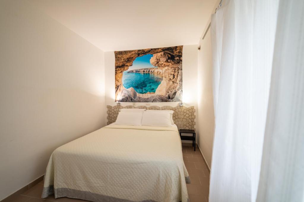 une chambre avec un lit et un tableau au mur dans l'établissement lidodubaihotel, à Marina di Ginosa