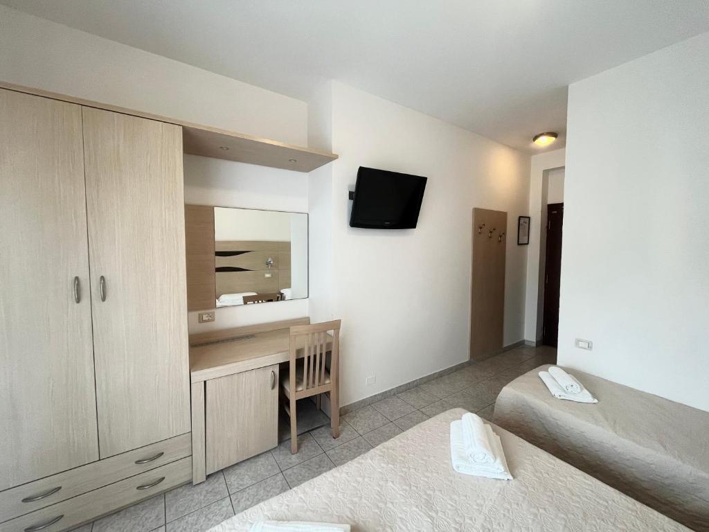 une chambre avec un lit, un bureau et un miroir dans l'établissement Hotel Rosen Garden, à Milano Marittima