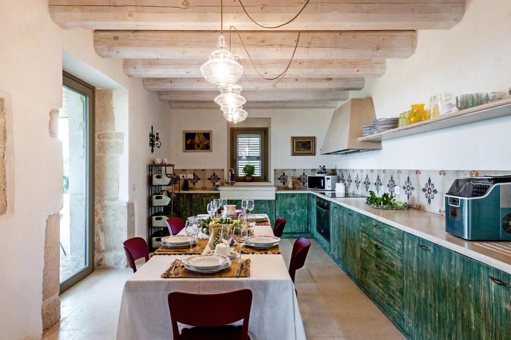 une salle à manger avec une table et une cuisine dans l'établissement Casale Donna Costanza, à Scicli
