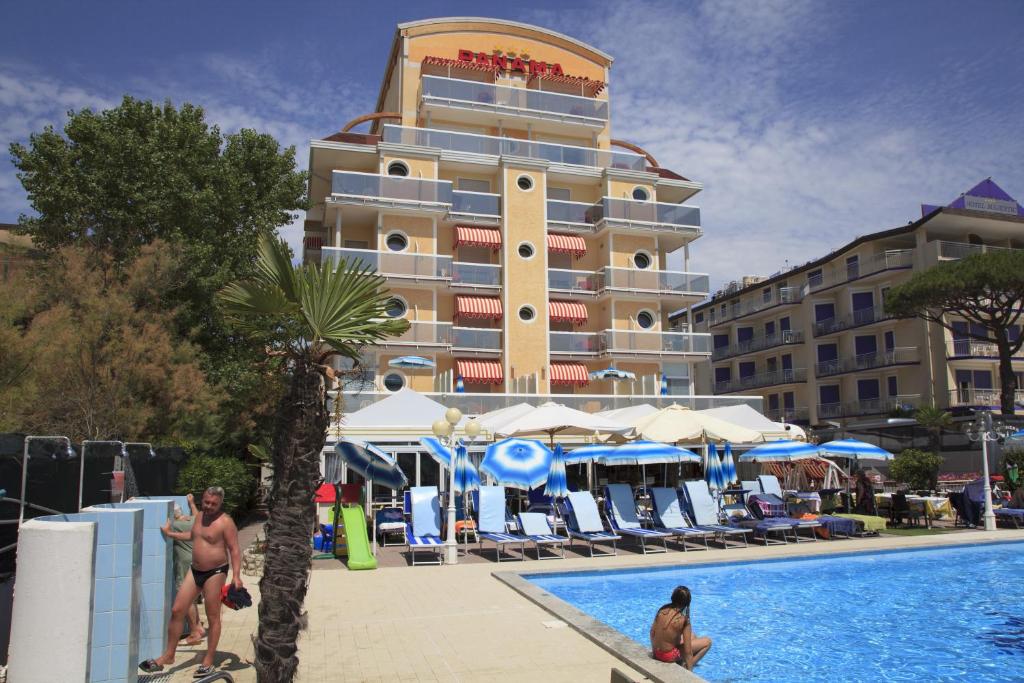 un hôtel avec une piscine devant un bâtiment dans l'établissement Hotel Panama, à Lido di Jesolo