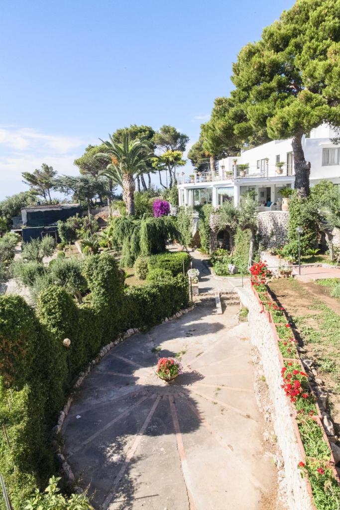 - une vue sur le jardin avec une maison en arrière-plan dans l'établissement Villa con piscina con 8 camere matrimoniali ad Anacapri, by La Canostra Capri, à Anacapri 147 autres photos