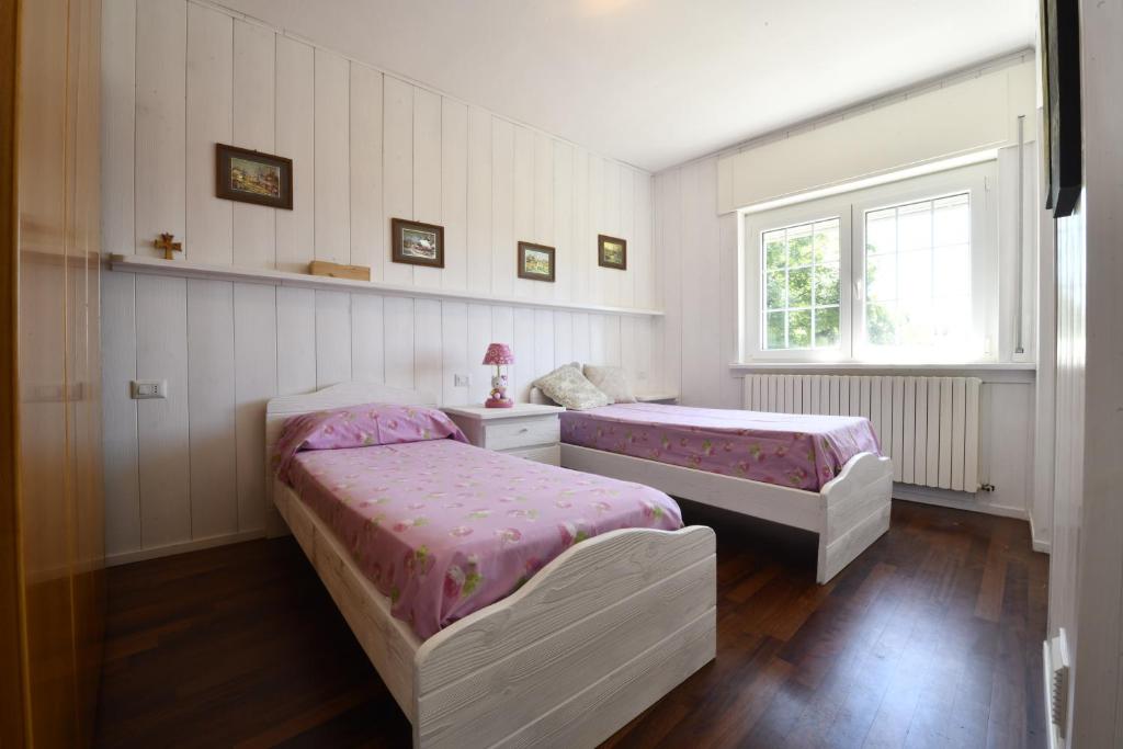 une chambre avec deux lits et une fenêtre dans l'établissement ANGEL'S VILLA - Panoramic LAKE VIEW, à Lecco