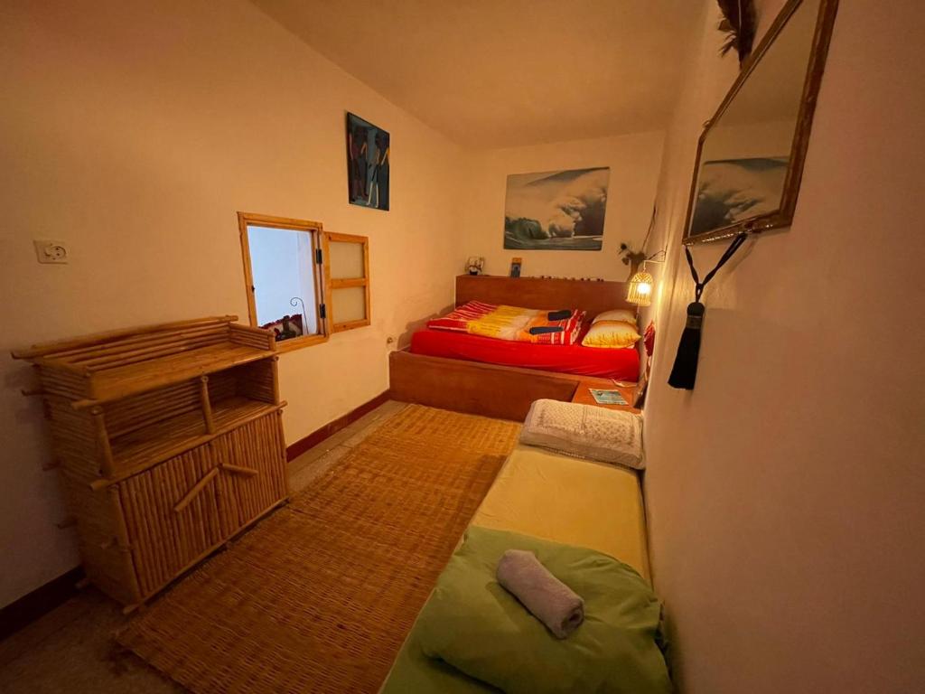 une chambre avec un lit, une commode et un miroir dans l'établissement SALAS waveclimbing company, à Sidi Ifni