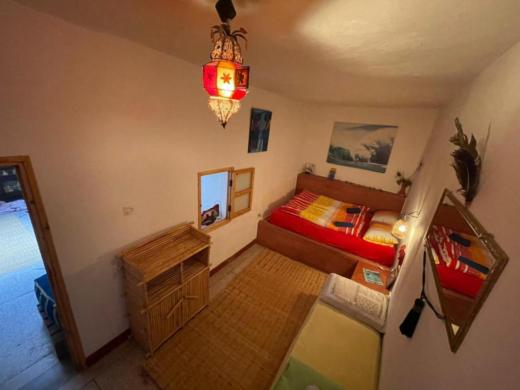 - une chambre avec un lit et un lustre dans l'établissement SALAS waveclimbing company, à Sidi Ifni
