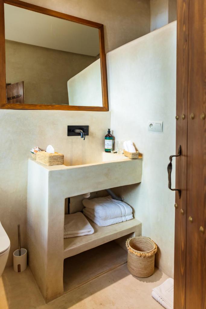 une salle de bain avec un lavabo, un miroir et des serviettes dans l'établissement Pure House Marrakech, à Marrakech