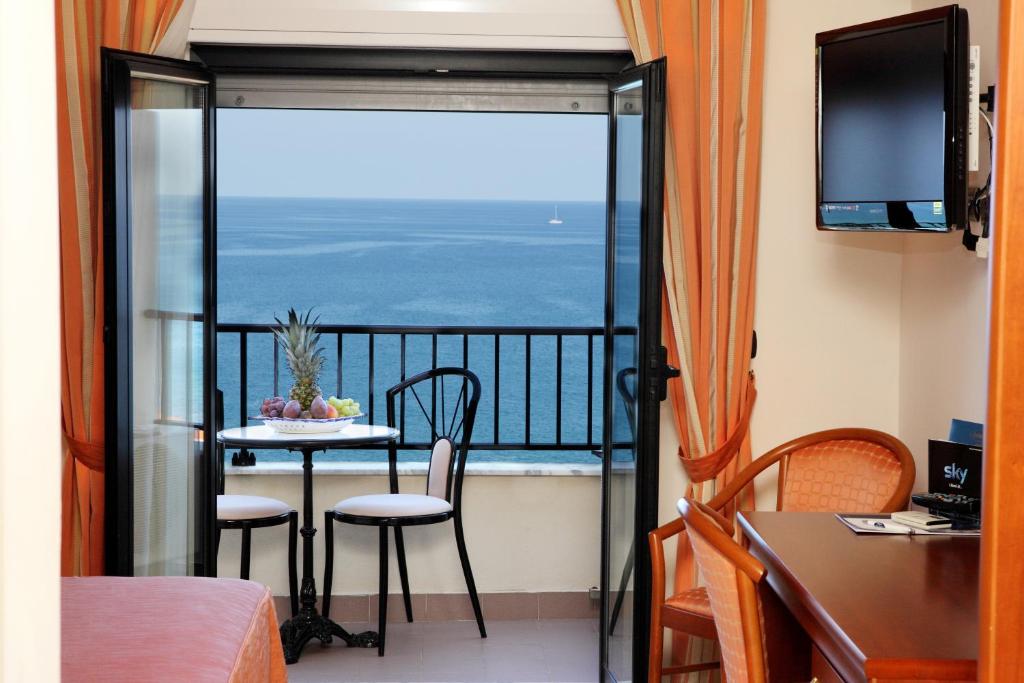 une chambre avec un balcon avec une table et des chaises dans l'établissement Hotel Za Maria, à Santo Stefano di Camastra