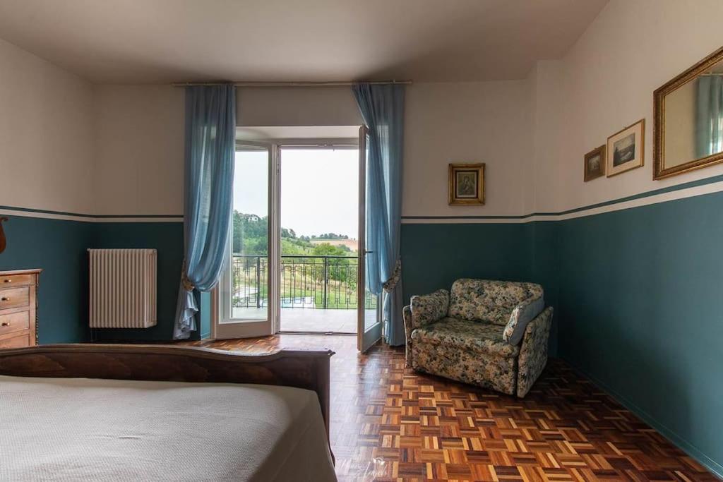 une chambre avec un lit, une chaise et une fenêtre dans l'établissement Villa Fiori, à Moncalvo 60 autres photos