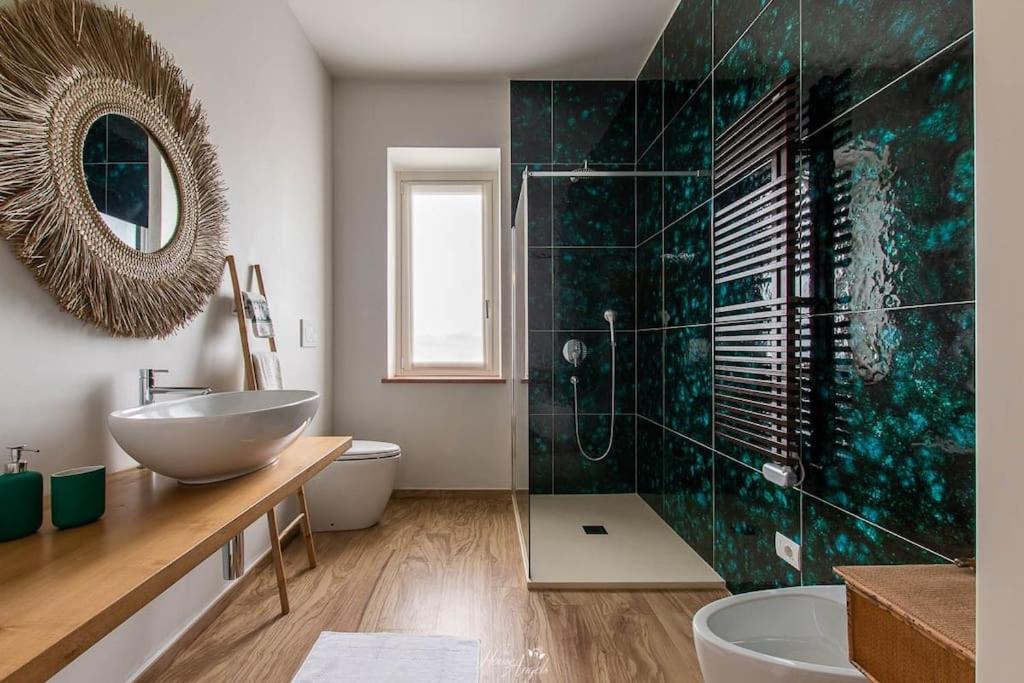une salle de bain avec un lavabo, des toilettes et un miroir dans l'établissement Villa Fiori, à Moncalvo
