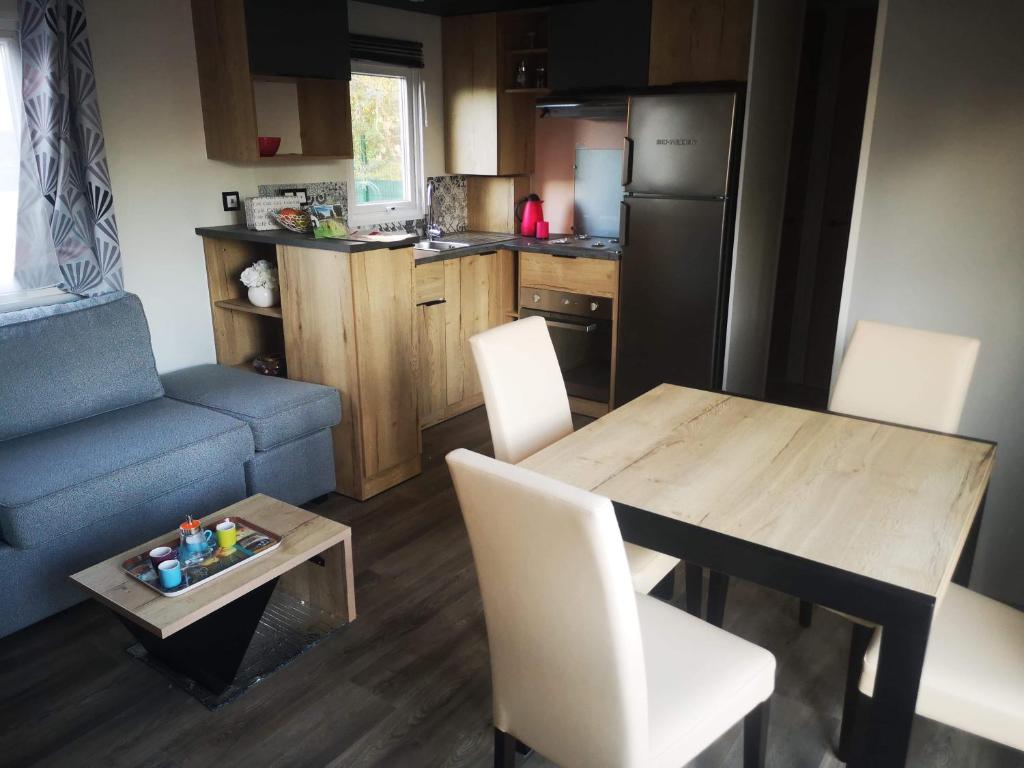 une petite cuisine avec une table et une table et des chaises dans l'établissement Mobil home 6/8 personnes camping 4*Frejus, à Fréjus