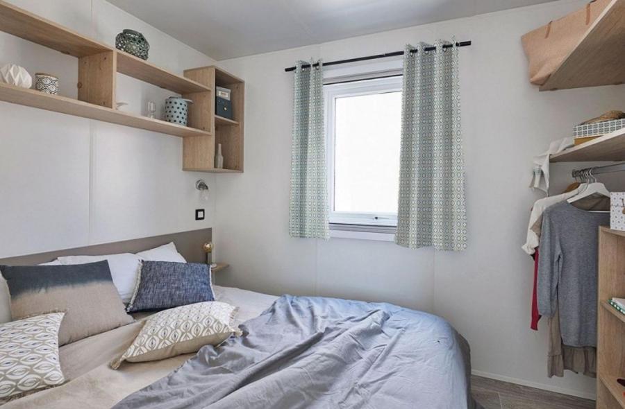 - une chambre avec un lit, une fenêtre et des étagères dans l'établissement Camping Aux Rives du Soleil, à Pont-de-Vaux 31 autres photos
