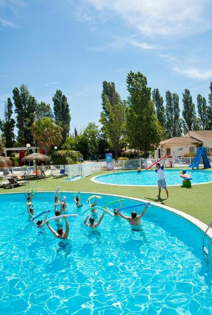un groupe de personnes jouant dans une piscine dans l'établissement Mobil home 6/8 personnes camping 4*Frejus, à Fréjus