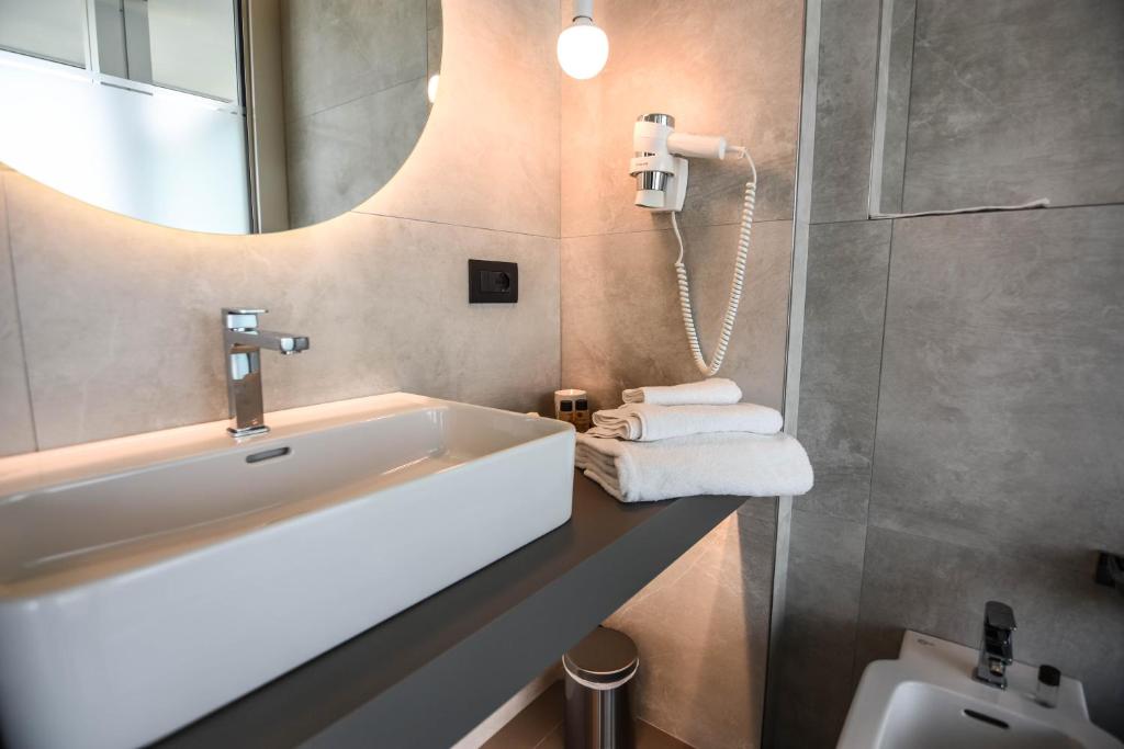 une salle de bain avec un lavabo et un miroir et des toilettes dans l'établissement Waldorf Suite Hotel, à Rimini