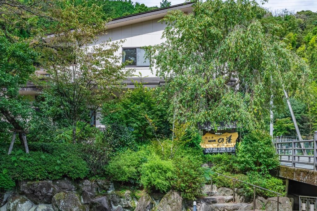 une maison entourée d'arbres et de buissons dans l'établissement Hidamari Ichinoyu, à Hakone