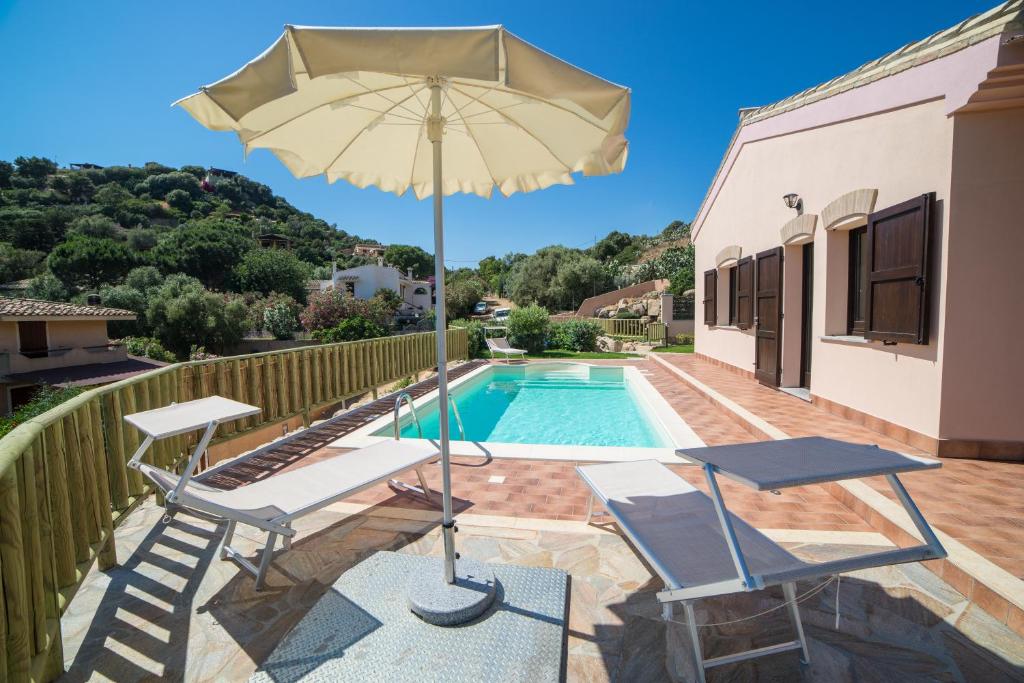 un patio avec deux chaises et un parasol à côté d'une piscine dans l'établissement Villa Ara, à Torre delle Stelle